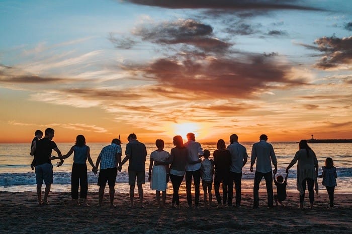 Grupo de personas en la playa anocheciendo