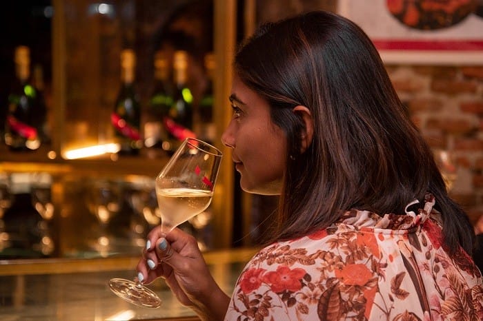 mujer oliendo su copa de champagne en una cata