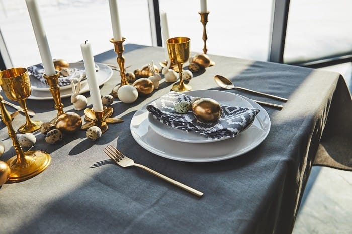 decoración de mesa con velas y vajillas dorada