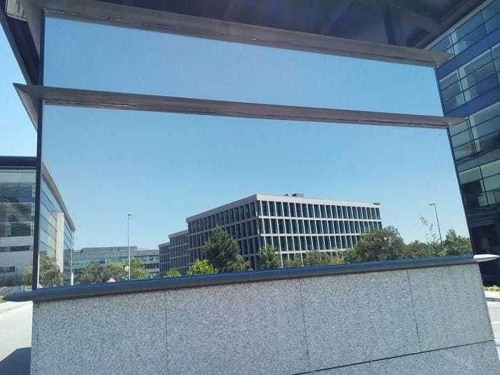 Detalle de una lámina solar espejo en la entrada de un edificio de oficinas