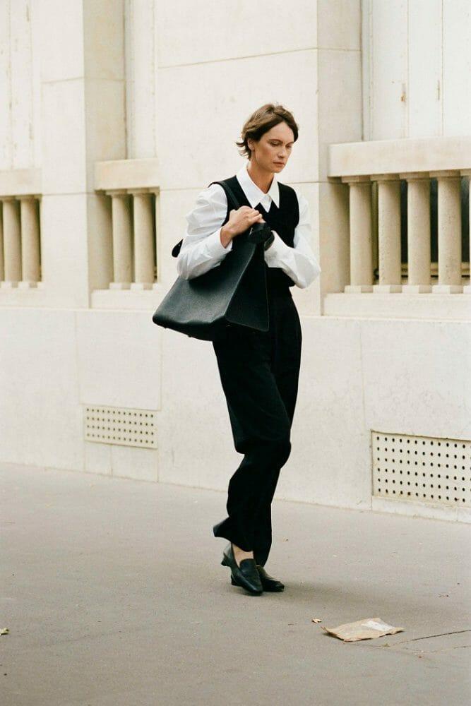 Modelo con bolso vestida de negro y calzado de cuña