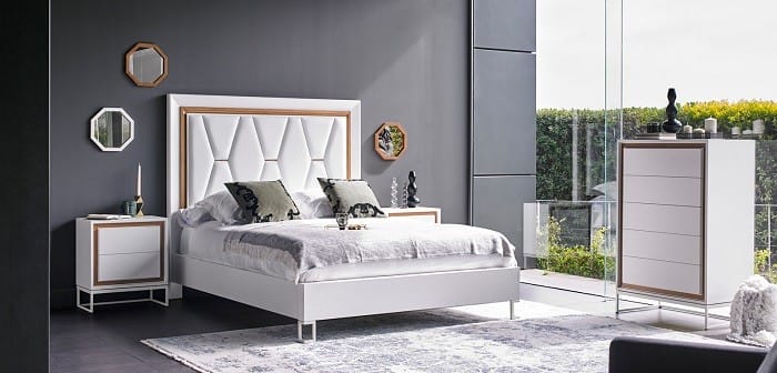 Interior de un dormitorio en tonos blancos con espejos en pared pequeños