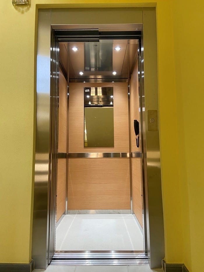 Interior de un ascensor con luces y espejo