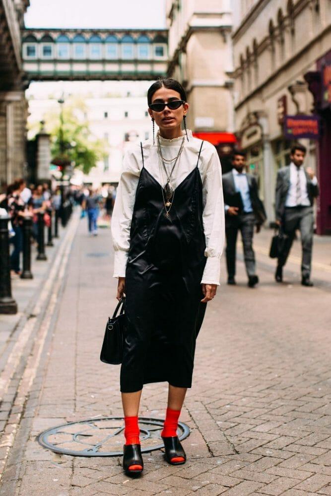 Modelo con un vestido negro y cuñas con calcetines rojos