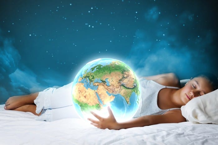 niña dormida con bola de mundo en las manos