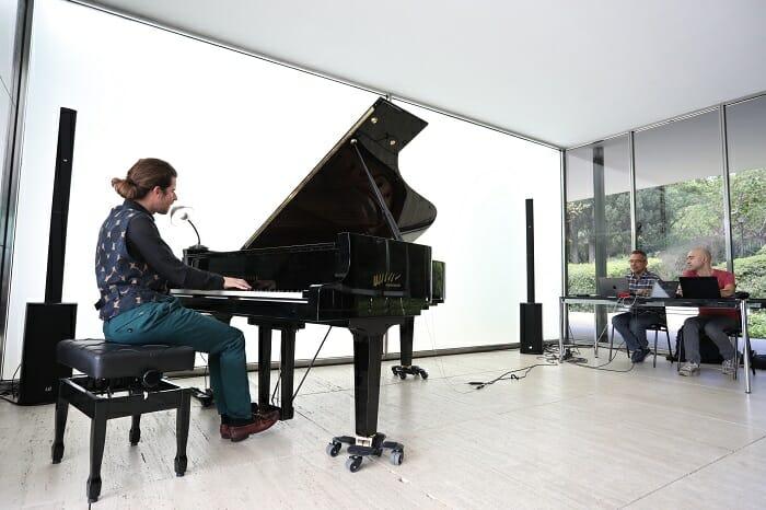 Pianista tocando el piano junto con inteligencia artificial mediante un portátil