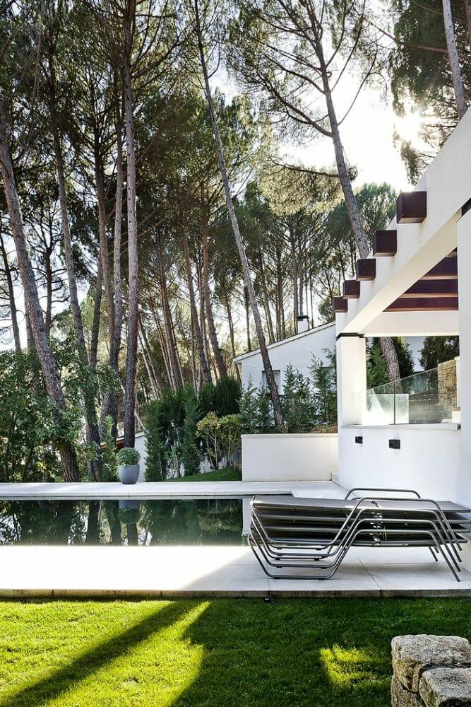 zona exterior de césped con piscina de una casa grande blanca