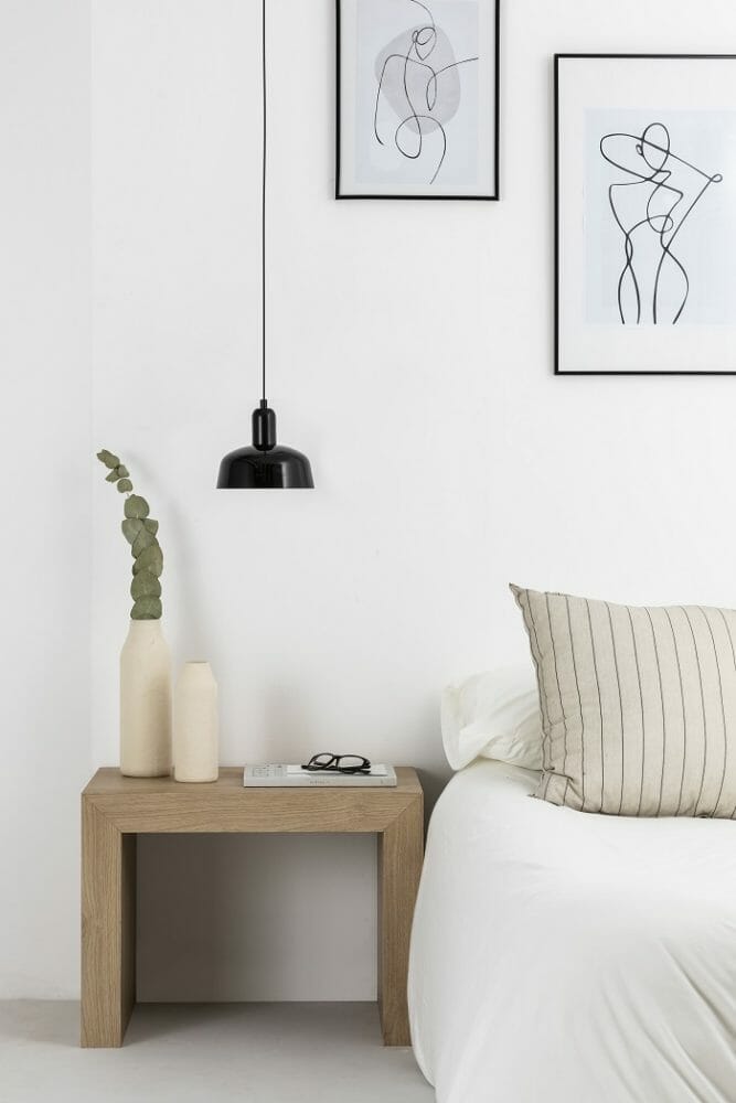 dormitorio con lámpara de techo encima de la mesilla