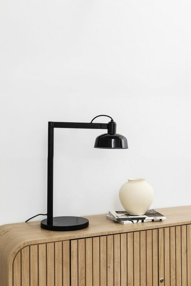 lámpara negra de flexo encima de un aparador