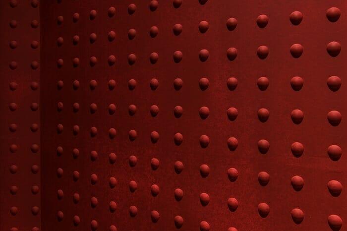 Detalle de una pared roja con bultitos del restaurante Tanuki