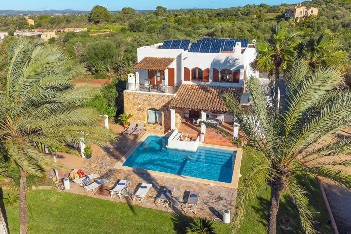 Vista aérea de una casa de vacaciones con varias plantas y piscina con tumbonas