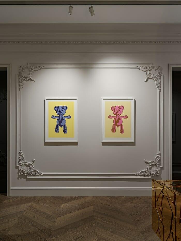 Pared con dos cuadros, decoración en relieve e iluminación