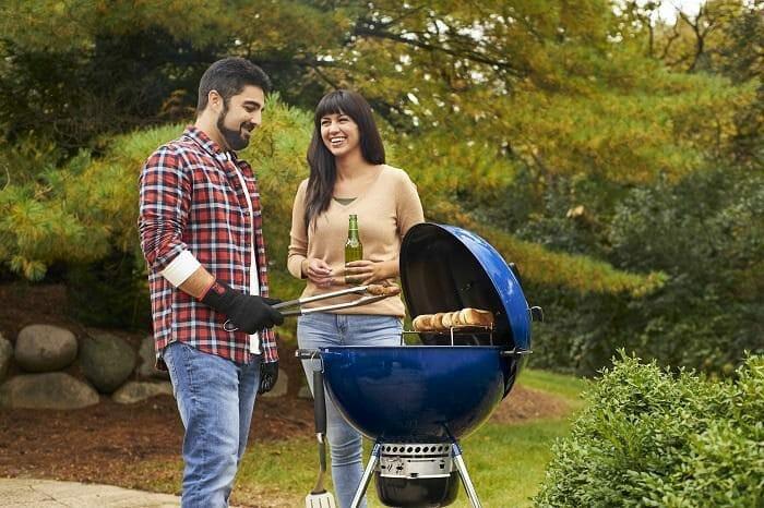 Amigos disfrutando de una barbacoa de carbón al aire libre