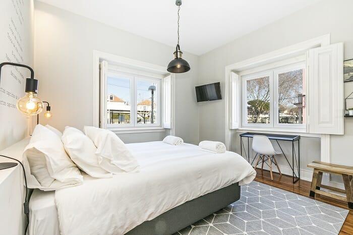 Dormitorio con decoración en blanco de un refugio en Estoril alojamiento Airbnb