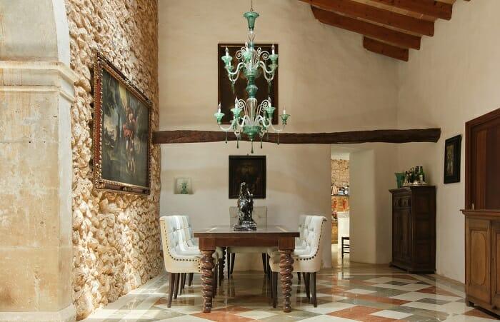 Zona de comedor con mesa larga y sillas en una casa rural antigua restaurada