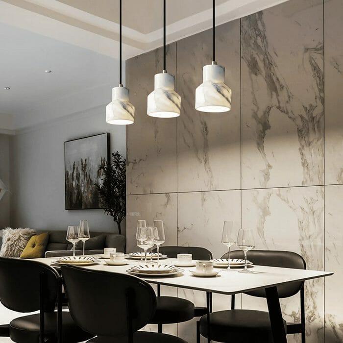 Tres lámparas colgantes de diseño encima de una mesa de comedor