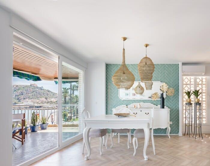 salón con mesa blanca estilo antiguo y terraza con vistas al mar