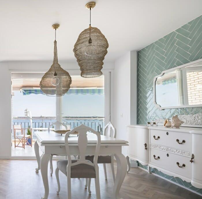 mesa y sillas de salón con una pared con azulejos de espiga color azul
