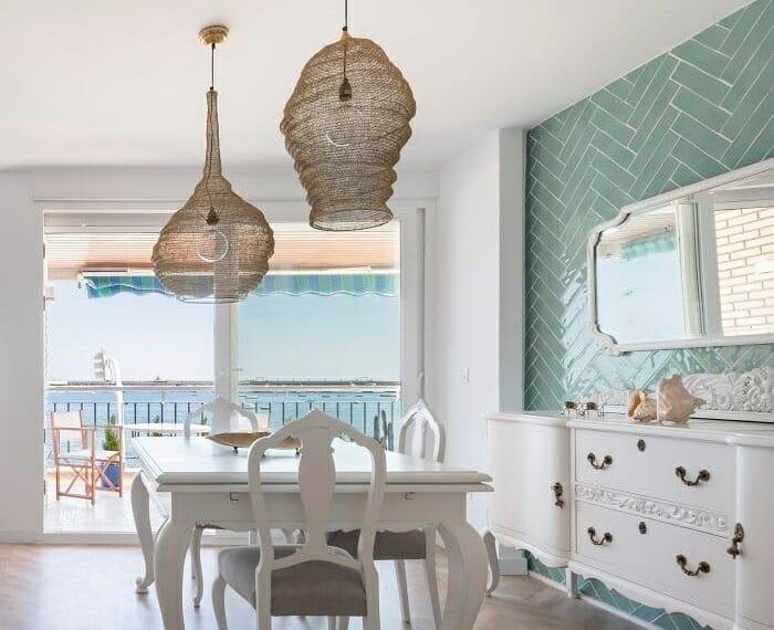 mesa y sillas de salón con una pared con azulejos de espiga color azul