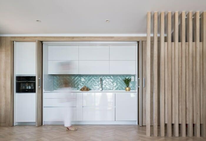 Cocina abierta en color blanco con azulejos en azul claro en forma de espiga