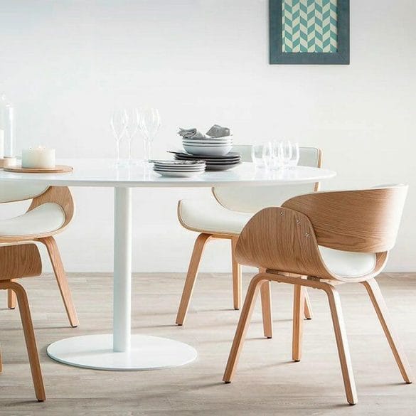 Sillas de diseño en blanco y madera en la mesa redonda de una cocina