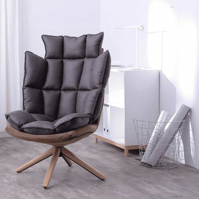 Sillón de diseño acolchado con patas de madera en un rincón de una habitación