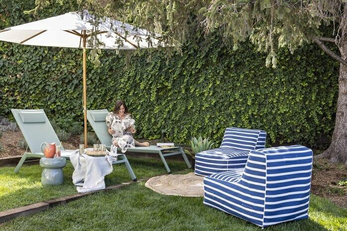 Zona exterior con tumbonas, sombrilla y dos sillones de exterior de Maisons du Monde