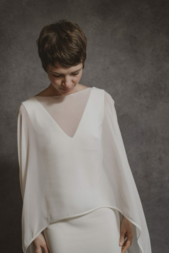 modelo con un vestido de novia blanco con tela por encima transparente