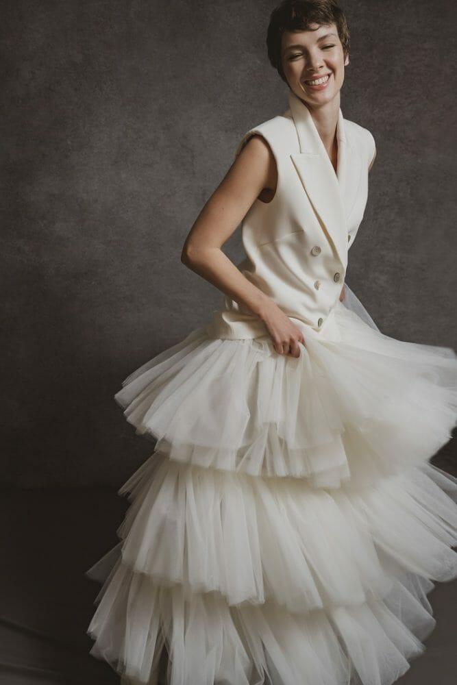 modelo con un vestido de novia blanco con falda tipo tul y parte de arriba tipo chaqueta sin mangas
