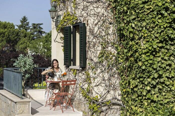 Terraza con vegetación con sillas y mesa rojas para exterior