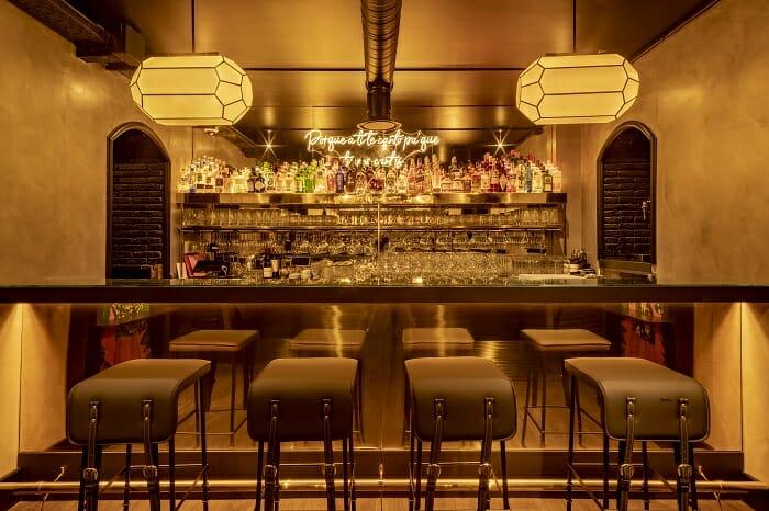 Gran barra iluminada con taburetes del Bam Karaoke Box en Madrid