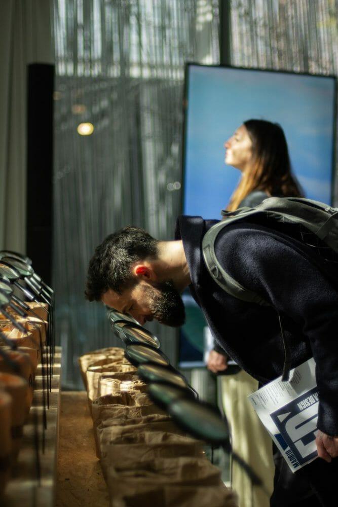 Chicos mirando por la lupa un saco de arena de la exposición Beyond the plastic wave