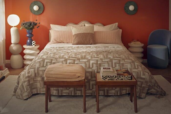 Dormitorio con pared rojo y cama con cojines de westwing efecto peluche