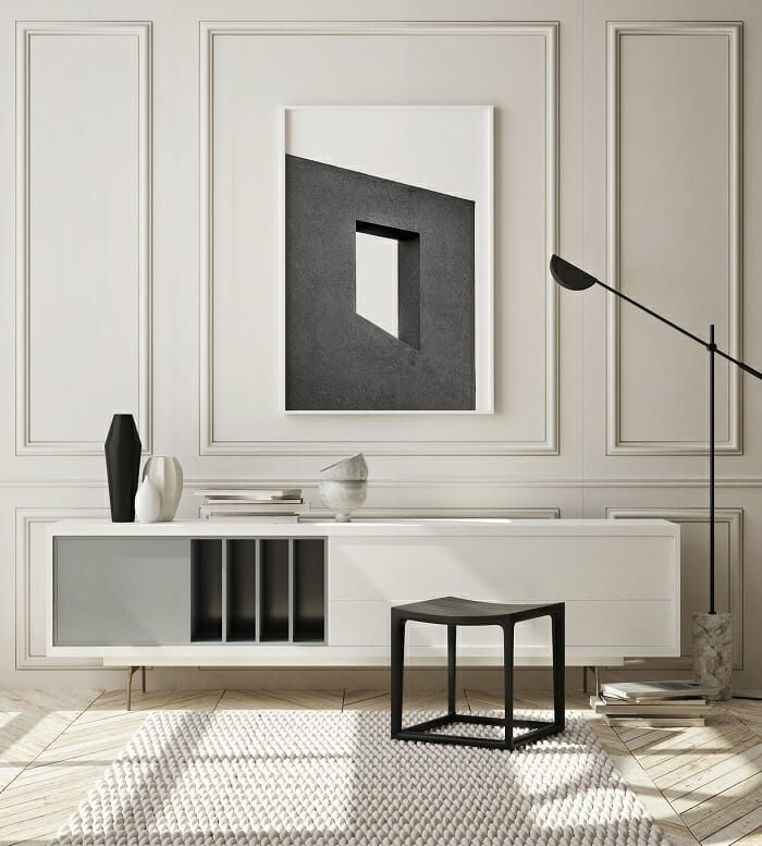 Aparador blanco y negro con una lámina encima en la pared decorativa