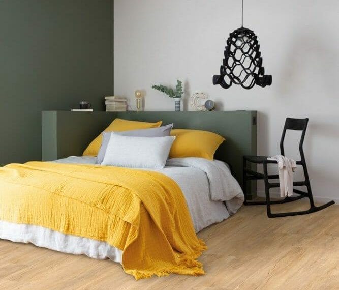 Habitación moderna con cama con textil blanco y amarillo y lámpara colgada