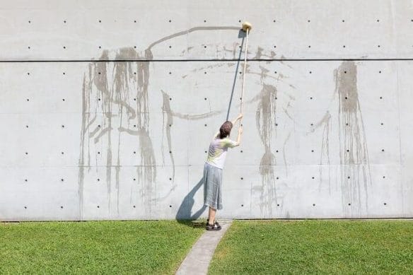 Persona pintando en la pared gris
