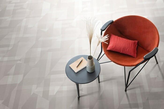 Una mesita pequeña redonda con un sillón rojo