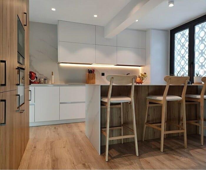 Cocina blanca con isla y taburetes