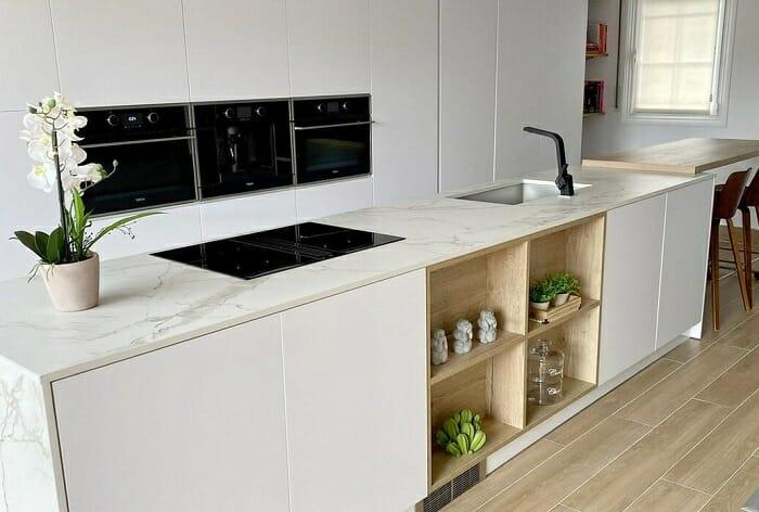 Cocina blanca abierta con isla con estantes