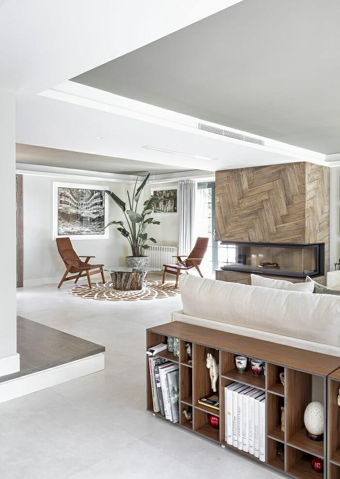 Salón con chimenea de diseño y zona de mesa con sillas