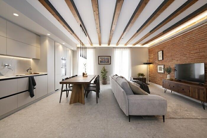 Cocina blanca abierta con salón con techo de vigas de madera