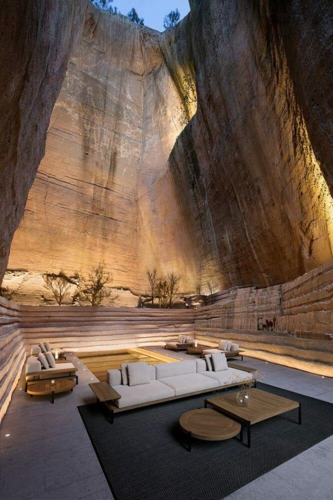 Sofá blanco de exterior y mesas de exterior en el fondo de una montaña iluminada