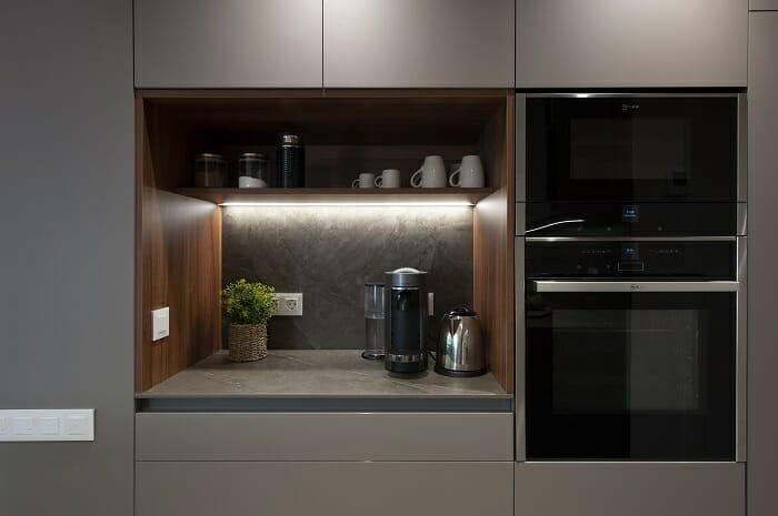 Zona de una cocina con un muebles desayunador con iluminación led