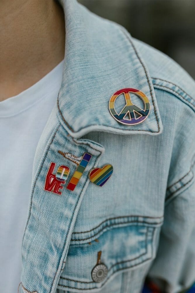 Varias chapas personalizadas con el arco iris en una cazadora vaquera como elemento decorativo