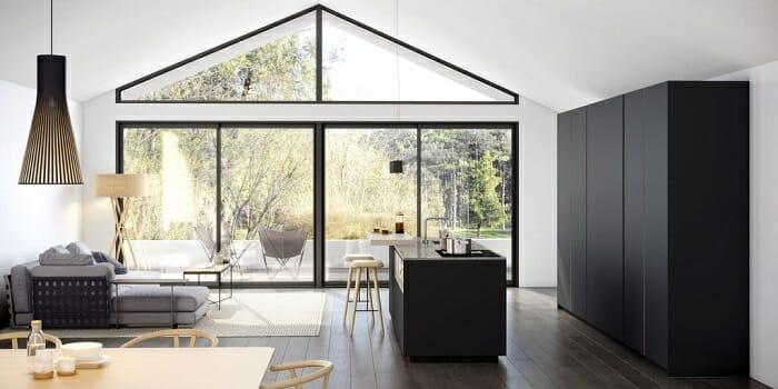 Cocina abierta con salón al lado con grandes ventanales