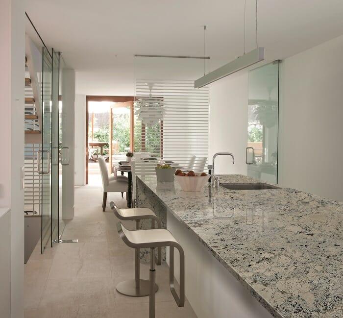 Cocina con una isla con taburetes larga