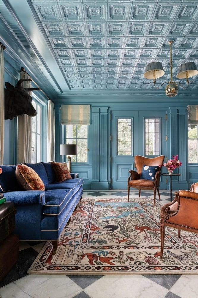 salón con sofá azul, techos azules con relieve y alfombra de diseño