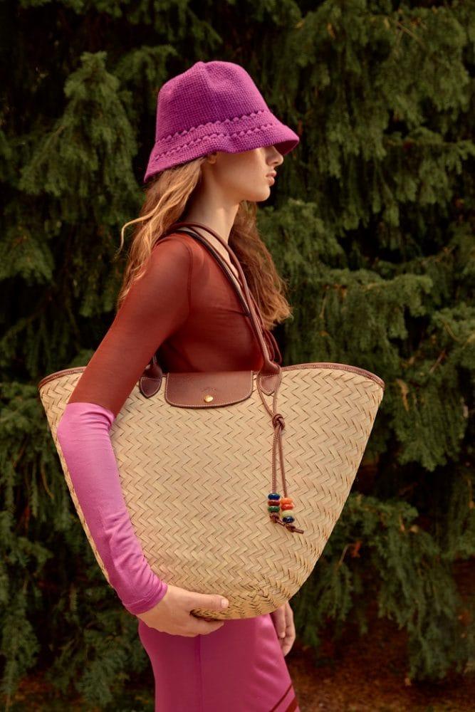 Modelo con un bolso grande de Longchamp y gorro fucsia