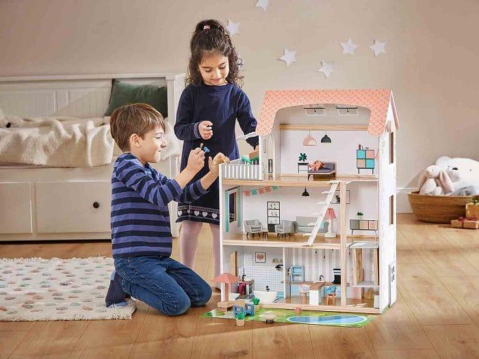 Niños jugando con una casa de muñecas de madera del Lidl
