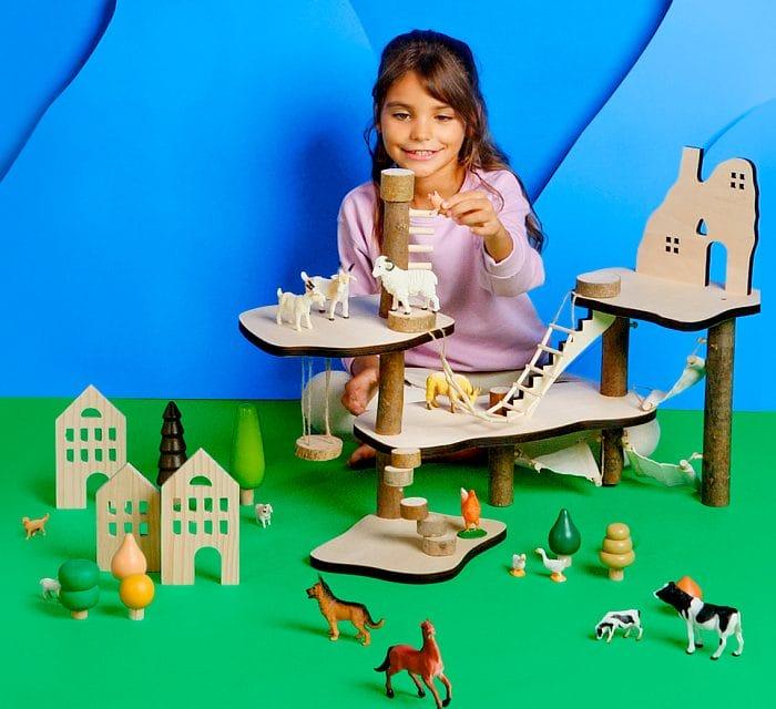 Niña jugando en una casa del árbol de madera de Aldi